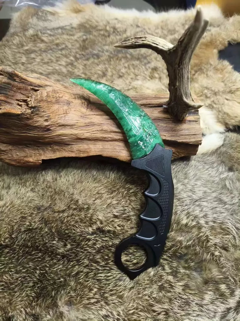 Hand-crafted stone-style karambit with deep green cat's-eye stone and metal handle; menacing karambit; Doppler Emerald karambit.