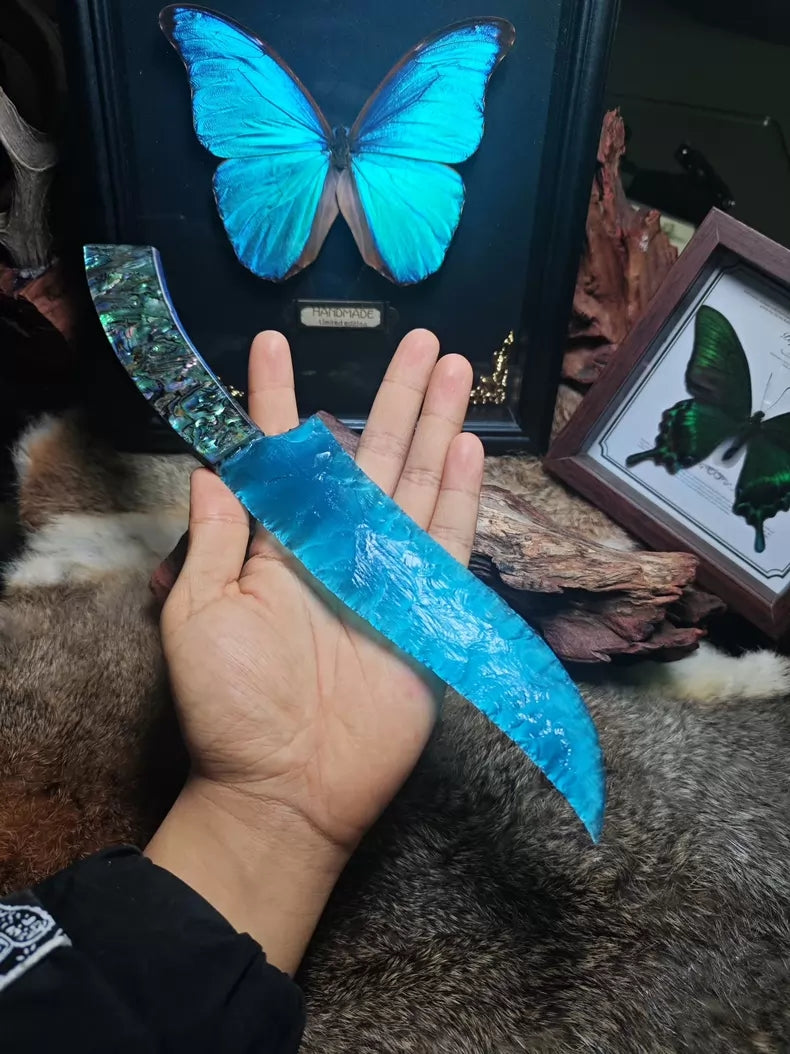 Hunting knife with a knapped stone blade, a handle made of colorful seashells, and a sky-blue cat's-eye stone blade.
