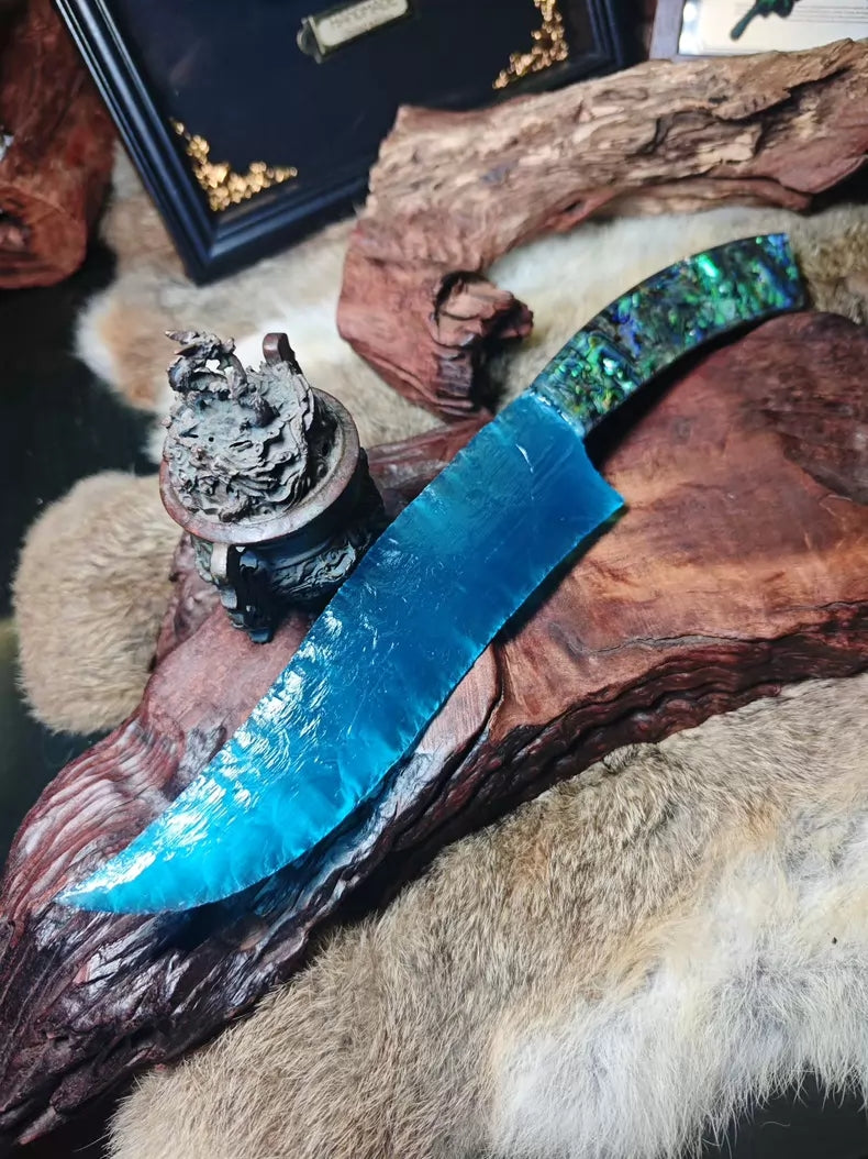 Hunting knife with a knapped stone blade, a handle made of colorful seashells, and a sky-blue cat's-eye stone blade.