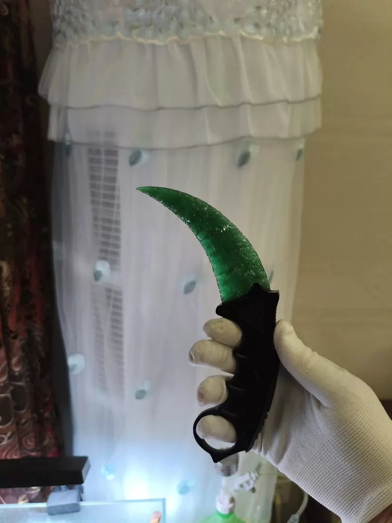 Hand-crafted stone-style karambit with deep green cat's-eye stone and metal handle; menacing karambit; Doppler Emerald karambit.