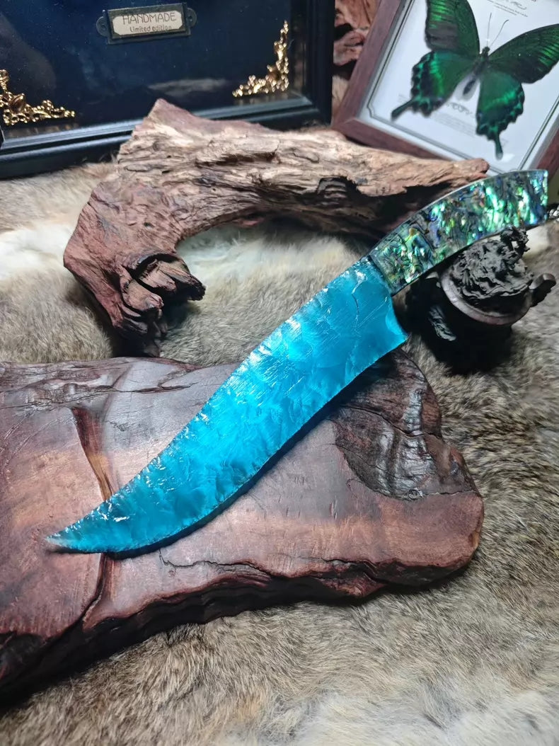 Hunting knife with a knapped stone blade, a handle made of colorful seashells, and a sky-blue cat's-eye stone blade.