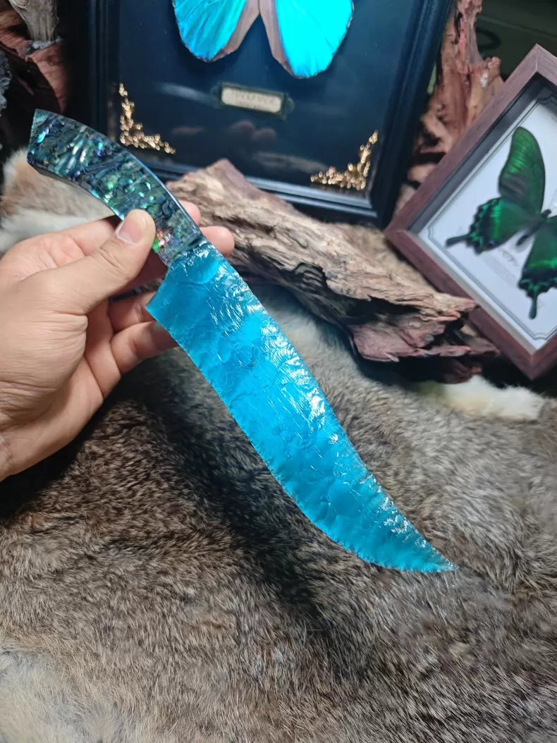 Hunting knife with a knapped stone blade, a handle made of colorful seashells, and a sky-blue cat's-eye stone blade.