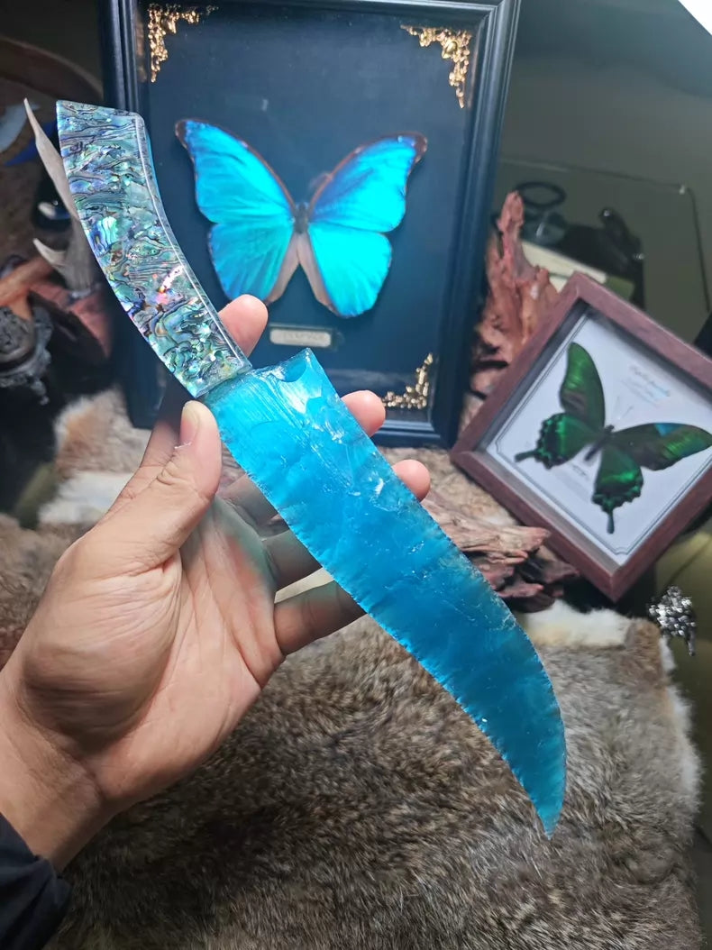 Hunting knife with a knapped stone blade, a handle made of colorful seashells, and a sky-blue cat's-eye stone blade.