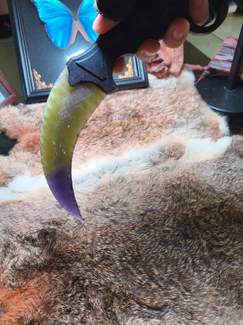 Flaked stone blade featuring the profile of a CS:GO Karambit, crafted with a colorful cat's-eye effect and pressure-flaking technique.