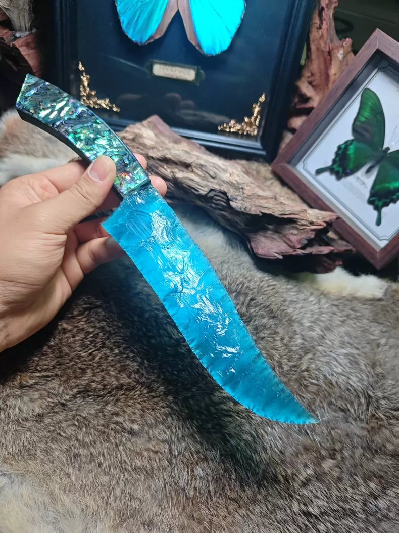 Hunting knife with a knapped stone blade, a handle made of colorful seashells, and a sky-blue cat's-eye stone blade.